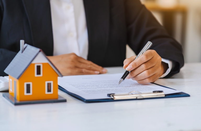 lawyer checks documents next to a model of a house