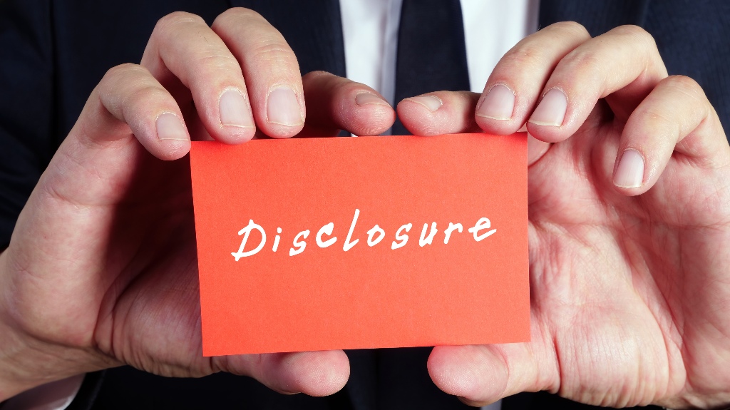 man holds a card with the inscription Disclosure in his hands