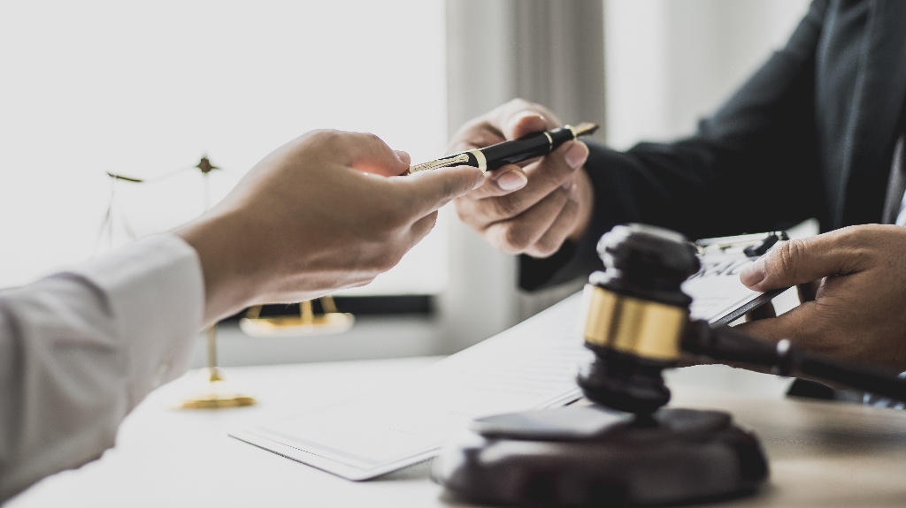 Attorney-gives-the-client-a-pen-to-sign-document_s